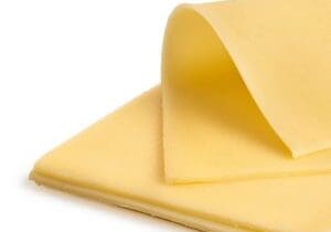 Sliced cheese Folded thin slice of yellow cheese on top of a stack of yellow cheese slices.